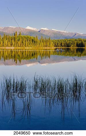 Stock Image - Fishermen On Boya Lake And Mountains At Sunset, Boya Lake Provincial Park, Northern British Columbia. Fotosearch