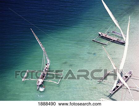 Stock Image - Fishermen Paddling Their Dhows Out To Sea. Fotosearch