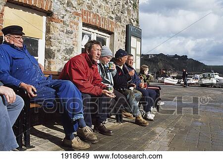Stock Photo - Fishermen Relax On The Port, Tenby. Fotosearch