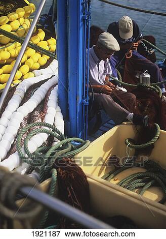 Stock Photo - Fishermen Repairing Nets. Fotosearch