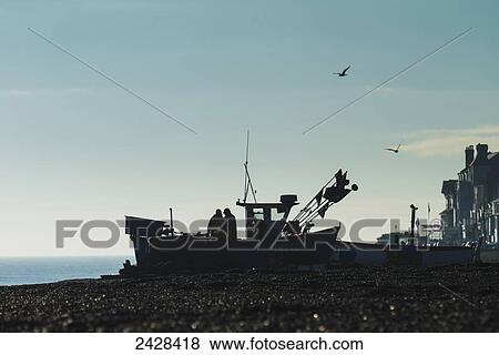 Fishermen sorting out their nets on boat on Aldeburgh beach; Suffolk, England View Large Photo Image Stock Photo - Fishermen sorting out their nets on boat on Aldeburgh beach; Suffolk, England. Fotosearch