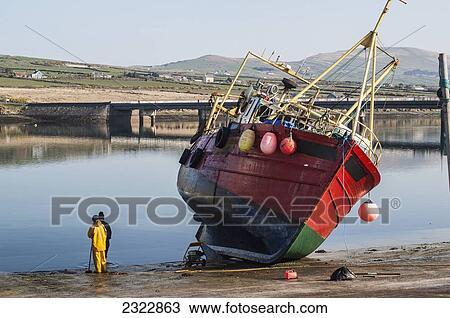 Fishermen standing on wet shore beside large fishing vessel; Portmagee, Iveragh Peninsula, County Kerry, Ireland, UK View Large Photo Image Stock Image - Fishermen standing on wet shore beside large fishing vessel; Portmagee, Iveragh Peninsula, County Kerry, Ireland, UK. Fotosearch