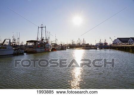 Stock Photography - Fishing Boat In The South Arm Of The Fraser River By The Historic Fishing Village Of Steveston At Dusk, Richmond, British Columbia, Canada. Fotosearch