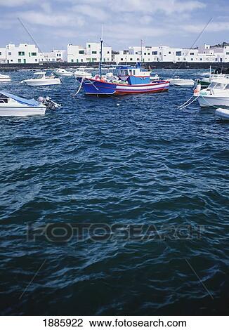 Stock Image - Fishing Boats In Harbor With Orzola In Background. Fotosearch