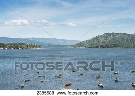 Fishing boats with mountains in the background; Valdivia, Los Rios, Chile View Large Photo Image Stock Photo - Fishing boats with mountains in the background; Valdivia, Los Rios, Chile. Fotosearch