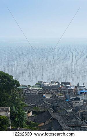 Fishing village and a structure made of posts in the water for hanging fishing nets to dry; Xiapu, Fujian, China View Large Photo Image Stock Image - Fishing village and a structure made of posts in the water for hanging fishing nets to dry; Xiapu, Fujian, China. Fotosearch