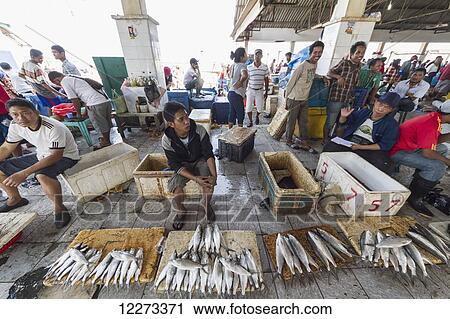 Stock Image - Fishmonger at the Paotere fish market, Makassar (Ujung Pandang), South Sulawesi, Indonesia. Fotosearch