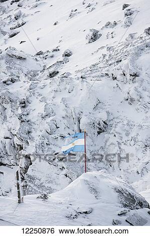 Stock Photograph - Flag of Argentina on a snow covered mountain slope; Patagonia, Argentina. Fotosearch