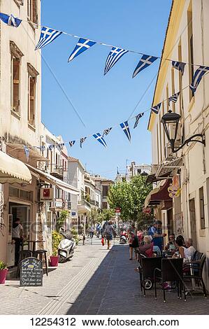 Stock Image - Flags hang over a narrow street; Chania, Crete, Greece. Fotosearch