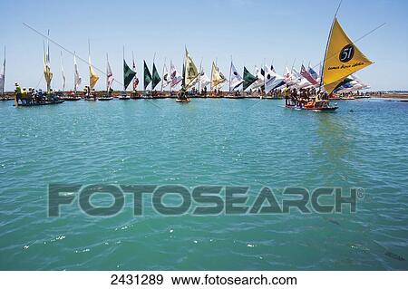 Stock Photo - Flat-bottomed sailing boats take tourists to see a coral reef at Porto de Galinhas; Pernambuco, Brazil. Fotosearch