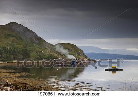 Stock Image - Floating Docks And Boats Moored At A Fish Farm Off The Shore; Ardnamurchan Argyl Scotland. Fotosearch