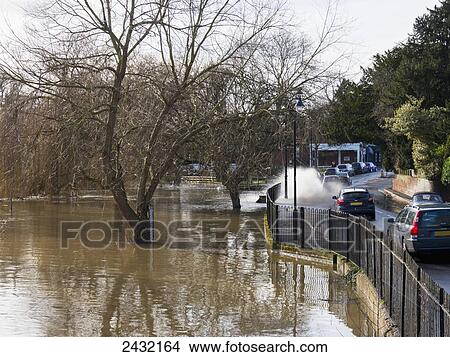 Picture - Flood water splashing on the road; Cobham, Surrey, England. Fotosearch