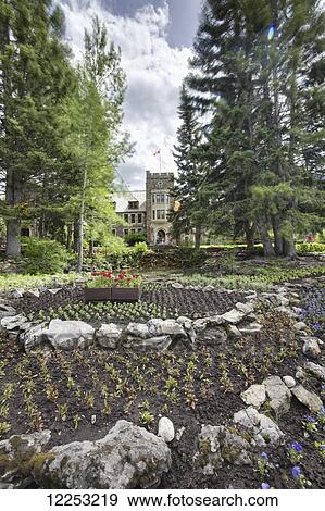 Stock Photo - Flowerbed in front of Banff National Park Administration Office; Banff, Alberta, Canada. Fotosearch