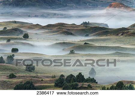 Stock Photo - Fog rolling over the landscape in Theodore Roosevelt National Park; North Dakota, United States of America. Fotosearch