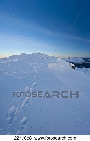 Stock Photo - Footprints in the snow on the summit of Beinn Respiol at dusk, Ardnamurchan peninsula; Highlands, Scotland. Fotosearch