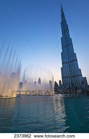 Stock Image - Fountain display in front of the Burj Khalifa at sunset; Dubai, United Arab Emirates. Fotosearch