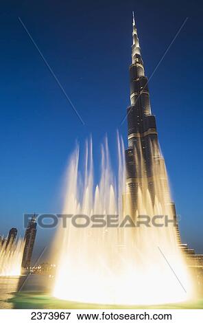 Stock Photo - Fountain display in front of the Burj Khalifa at sunset; Dubai, United Arab Emirates. Fotosearch