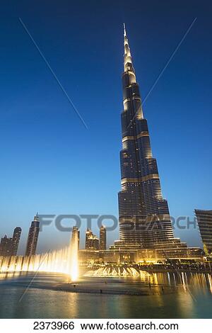 Stock Photograph - Fountain display in front of the Burj Khalifa at sunset; Dubai, United Arab Emirates. Fotosearch