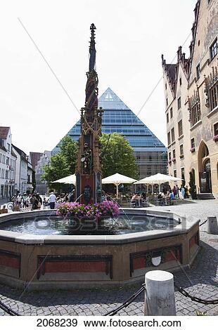 Fountain In The Marketplace With The New Central Library In The Background; Ulm Baden-Wurtenburg Germany View Large Photo Image Stock Photo - Fountain In The Marketplace With The New Central Library In The Background; Ulm Baden-Wurtenburg Germany. Fotosearch