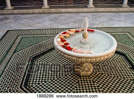 Stock Photograph - Fountain With Flowers In Courtyard. Fotosearch