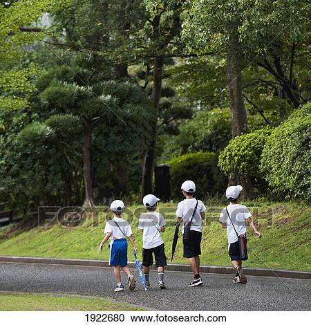 Stock Image - Four Boys Walking Down A Path In The Peace Park; Nagasaki, Japan. Fotosearch