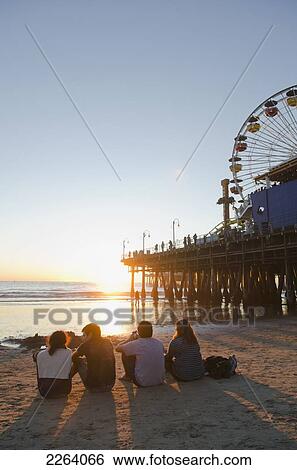 Four Friends Sitting On The Beach Next To Santa Monica Pier; Los Angeles California Usa View Large Photo Image Stock Photograph - Four Friends Sitting On The Beach Next To Santa Monica Pier; Los Angeles California Usa. Fotosearch
