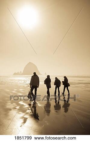 Four People Walking On The Beach; Cannon Beach, Oregon, Usa View Large Photo Image Stock Photo - Four People Walking On The Beach; Cannon Beach, Oregon, Usa. Fotosearch