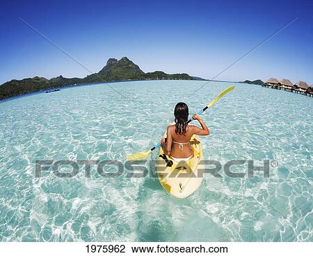 Stock Image - French Polynesia, Bora Bora, Female Kayaker Enjoying A Day On The Water.. Fotosearch