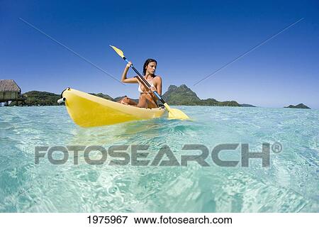 Stock Photo - French Polynesia, Bora Bora, Female Kayaker Enjoying A Day On The Water.. Fotosearch