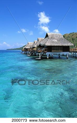 Stock Image - French Polynesia, Bora Bora Lagoon Resort Bungalows Over Water, Side View From Ocean C1782. Fotosearch