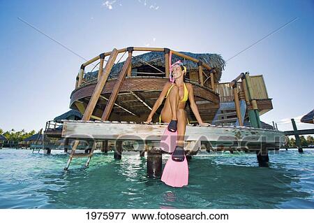 French Polynesia, Bora Bora, Woman Sits On The Dock Of A Bungalow Before Snorkeling. View Large Photo Image Stock Photo - French Polynesia, Bora Bora, Woman Sits On The Dock Of A Bungalow Before Snorkeling.. Fotosearch