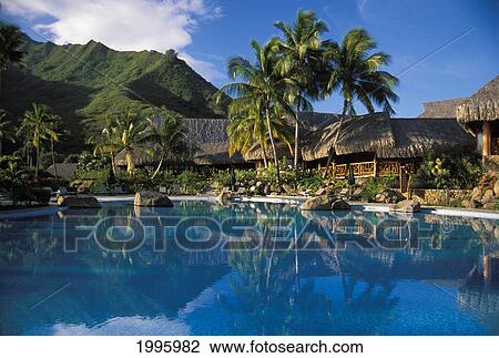 Stock Image - French Polynesia, Moorea Sheraton, Pool Side View Of Bungalows, Mountain Background.. Fotosearch