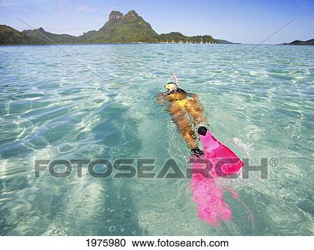 Stock Image - French Polynesia, Moorea, Woman Free Diving In Turquoise Ocean.. Fotosearch