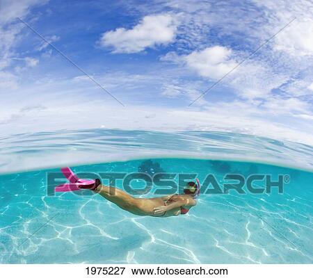 Stock Photo - French Polynesia, Moorea, Woman Free Diving In Turquoise Ocean.. Fotosearch