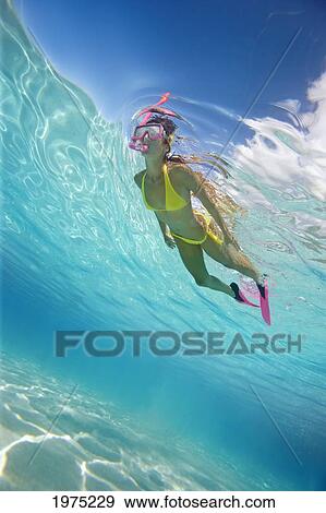 Stock Photo - French Polynesia, Moorea, Woman Free Diving In Turquoise Ocean.. Fotosearch