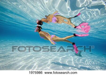 Stock Photograph - French Polynesia, Moorea, Woman Free Diving In Turquoise Ocean.. Fotosearch