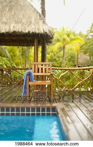 Picture - French Polynesia, Tahiti, Bora Bora, Deck Chair With Towel Hanging Over It Next To Swimming Pool, Tropical Vegetation, Selective Focus. Fotosearch