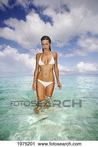 Stock Image - French Polynesia, Tahiti, Bora Bora, Woman Walking In The Ocean.. Fotosearch