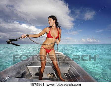 Stock Image - French Polynesia, Tahiti, Bora Bora, Woman On A Boat Throws Anchor.. Fotosearch