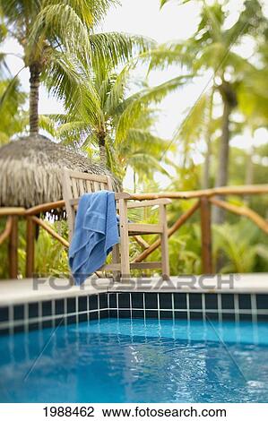 French Polynesia, Tahiti, Bora Bora, Deck Chair With Towel Hanging Over It Next To Swimming Pool, Tropical Vegetation, Selective Focus View Large Photo Image Stock Image - French Polynesia, Tahiti, Bora Bora, Deck Chair With Towel Hanging Over It Next To Swimming Pool, Tropical Vegetation, Selective Focus. Fotosearch
