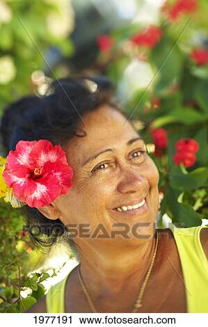 Stock Image - French Polynesia, Tahiti, Maupiti, Local Women With Hibiscus Flower.. Fotosearch