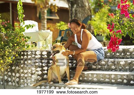 Stock Photo - French Polynesia, Tahiti, Maupiti, Local Women In Yard With Dog.. Fotosearch