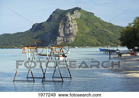 Stock Photo - French Polynesia, Tahiti, Maupiti, Lagoon With Boats, Docks And Mountain.. Fotosearch