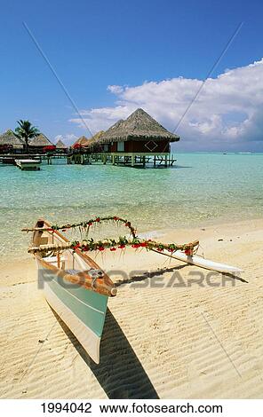 French Polynesia, Tahiti, Moana Beach Park Royal Resort, Bungalows Over Ocean, Outrigger Canoe On Beach In Foreground View Large Photo Image Stock Image - French Polynesia, Tahiti, Moana Beach Park Royal Resort, Bungalows Over Ocean, Outrigger Canoe On Beach In Foreground. Fotosearch