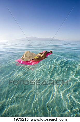 Stock Photography - French Polynesia, Tahiti, Moorea, Woman Floating In Water.. Fotosearch
