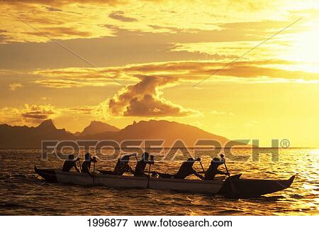 Stock Photo - French Polynesia, Tahiti, Papaeete, Men In Outrigger Canoe Paddling At Sunset, Golden Sunlight And Reflections On Ocean. Fotosearch