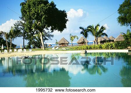 Stock Image - French Polynesia, Tahiti, Punauia, Le Meridian Resort Pool With Reflections, Ocean In Background. Fotosearch