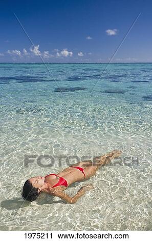 Stock Image - French Polynesia, Tahiti, Rangiroa, Woman Floating In Water.. Fotosearch