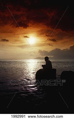French Polynesia, Tahiti, Silhouette Of Local Boy Fishing At Sunset, Colorful Sky. View Large Photo Image Stock Image - French Polynesia, Tahiti, Silhouette Of Local Boy Fishing At Sunset, Colorful Sky.. Fotosearch