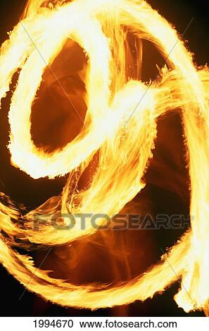 Stock Image - French Polynesia, Tahiti, Tahitian Fire Dancer In Action, Blurred Motion At Night. Fotosearch